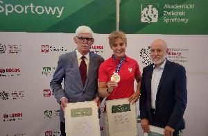 Srebrna medalistka z Tokio, Katarzyna Ziellmann i przedstawiciele AZS Toruń, z listami gratulacyjnymi 